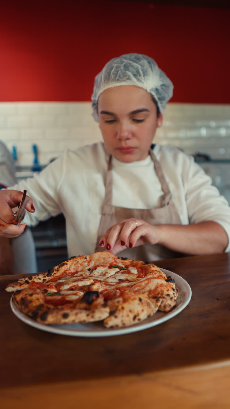 Uma participante sorrindo diante da pizza que acabou de assar.