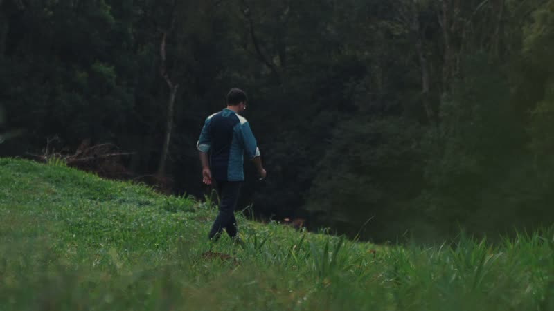 O vale verde do Bom Jardim, com mata fechada na encosta e uma pessoa atravessando o pasto.