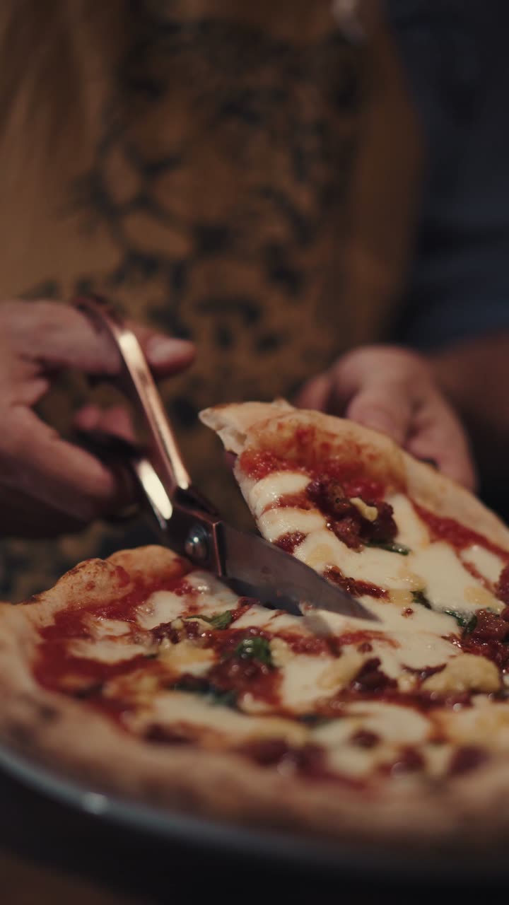 Uma pizza sendo cortada na mesa enquanto o Gerardo explica como comê-la.